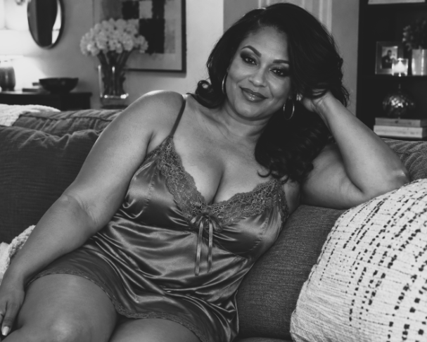 Woman sitting on a couch wearing lingerie.